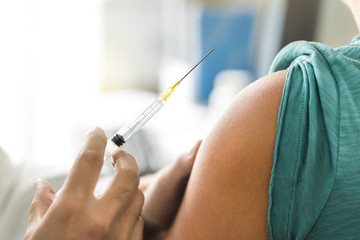 vaccine or flu shot in injection needle. doctor working with patient's arm. physician or nurse givin