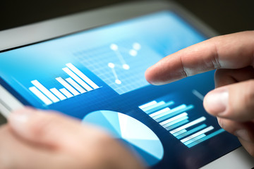 Statistics, graphs, trends and growth on tablet screen. Financial management and development with technology in business. Businessman using monitor to analyze market performance and figures.