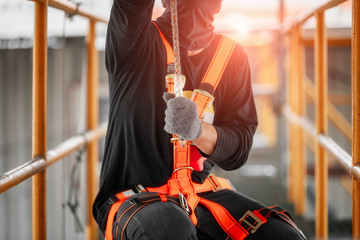 Construction worker wearing safety harness and safety line working high place at industrial.