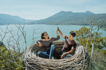 Wall Mural - couple highfive together while sitting on a nest 