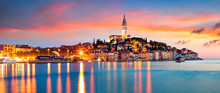 Fantastic Spring Sunset Of Rovinj Town, Croatian Fishing Port On The West Coast Of The Istrian Peninsula. Colorful Evening Seascape Of Adriatic Sea. Traveling Concept Background.
