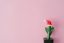 Tropical Summer Cactus Plant With Santas Hat On Pink Background With Copy Space. Minimal Flat Lay Christmas Theme. New Year Sale Concept.
