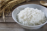 Fototapeta  - Jasmine rice in  bowl and paddy rice on a brown wooden background beautiful Thai food