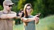 © johnalexandr - the instructor teaches the girl to shoot a pistol at the range