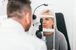 © Photocreo Bednarek - Woman undergoing eyesight exam in optician's office.