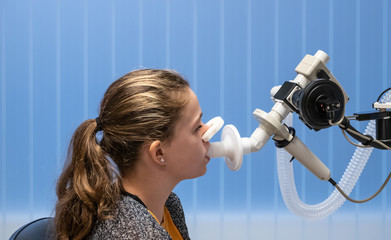 A young asthmatic girl having a lung function test.