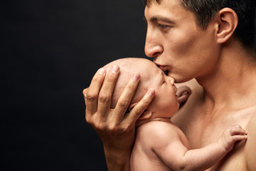 Wall Mural - asian father kissing adorable baby. copy space. best day in the life. copy space