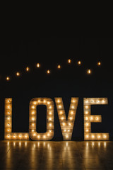 Wall Mural - the word love wood with light.