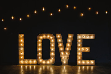 Wall Mural - the word love wood with light.