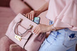 © cherry_d - Beautiful young blonde woman with light pink handbag and mobile phone. Portrait of pretty blonde girl in pink clothes.