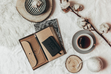 Wall Mural - Stylish Flat lay cup of tea with black notebooks on warm plaid . Top view, hipster composition