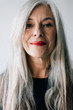 © Stocksy - Portrait of an attractive senior woman with grey long hair looking at camera.