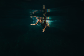 A child swims in dark blue deep freshwater in Florida.