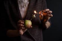 Unrecognizable Person Holding Apple And Trying To Light Star-shaped Candle With Match