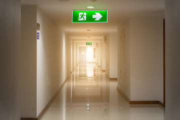 green emergency exit sign in hotel showing the way to escape