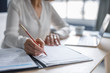 © Stocksy - Businesswoman Writing at Work