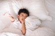 © pookpiik - 3 years old little cute Asian boy at home on the bed, kid lying playing and smiling on white bed with pillow and blanket, top view with copy space.