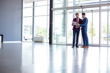 Wall Mural - businessmen studying papers at hall