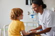 © Stocksy - Doctor female giving attention and care to child in a hospital room