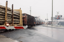 Freight Train Carrying Lumber At A Crossing In The Snow