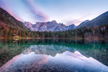 Wall Mural - Beautiful sunset landscape of Lago or Laghi di Fusine lake in Italy with spruces and mountains on shore