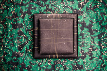 Two Gifts In Black Wrapping On Funky Green Background