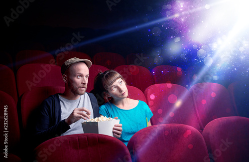 Fotografía Romantic couple cuddling and watching the miraculous part of the film