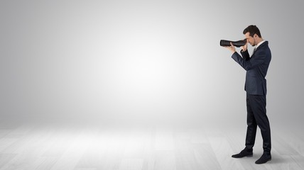 Wall Mural - businessman looking forward with binoculars in an empty space