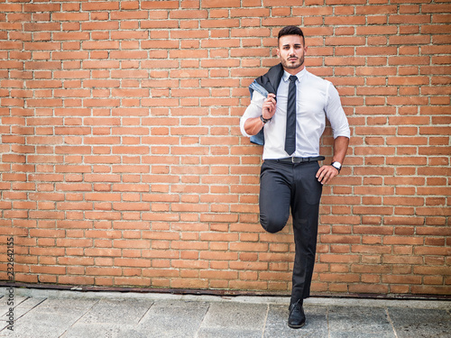 Fotografía Portrait of stylish young man wearing business suit, standing in modern city set