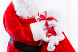 Fototapeta Na ścianę - Santa holding a present box from a red sack isolated on white background