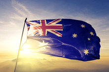 Australia Australian Flag Textile Cloth Fabric Waving On The Top Sunrise Mist Fog