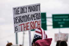 Protest: Protester Holds Sign Decrying The Policies Of The Rich