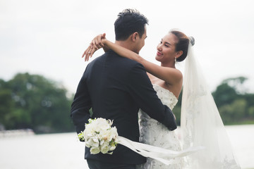 asia bride and groom on the background of river nature