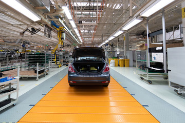 Wall Mural - Assembled car is on the Assembly line. Robotic equipment makes the Assembly of the car. Modern car Assembly at the factory