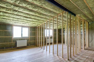 Wall Mural - Construction and renovation of big light spacious empty room with oak floor, walls and ceiling insulated with rock wool, heating radiators under low attic windows and wooden frame for future walls.