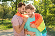 Happy gay couple with rainbow flag outdoors