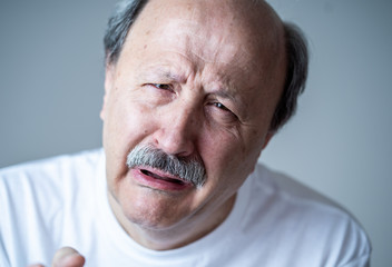 Close up portrait of sad old man face suffering from depression