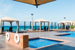 The edge of a cafe umbrella, cabanas, and pool at a resort near the ocean in Ensenada, Mexico.  