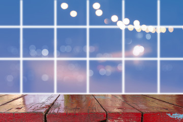 Canvas Print - wooden desk with blurred light on road in city with bokeh abstract background