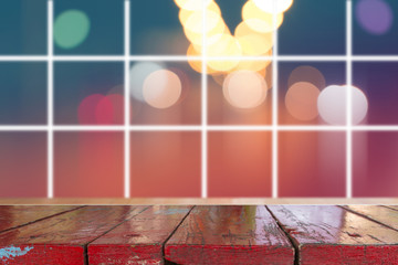 Canvas Print - wooden desk with blurred light on road in city with bokeh abstract background