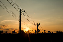 An Old Power Pole With Line On Silhouette Environment, High Level Of Noise. Sun Rise Or Sun Set Time