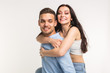 © satura_ - Emotional, love and people concept - young woman climbed the guy on the back and they happy and smile
