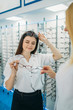 Optician and customer chooses glasses frame