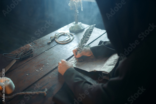 Fotografía Medieval monk sitting at table and write, top view