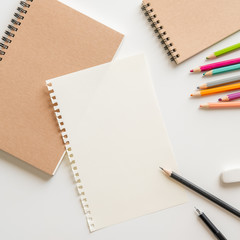 Wall Mural - blank paper with spiral notebook, pencil, eraser and color pencil on white background. empty space f