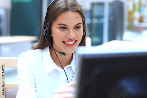 Fotografía Female customer support operator with headset and smiling.
