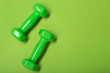 © aneduard - two green dumbbells on a green background, concept, copy space