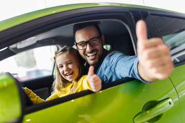 Wall Mural - Father and daughter buying a new car at the car showroom.