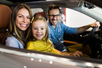 Wall Mural - Happy family buying a new car at the car showroom.