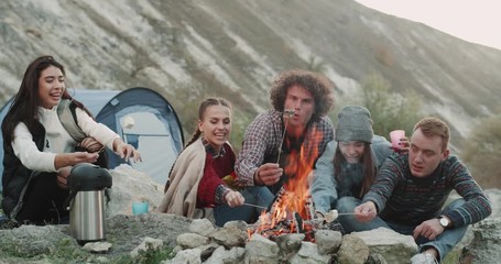 marshmallows time for a group of friends in the middle of mountain at camping, making some marshmall